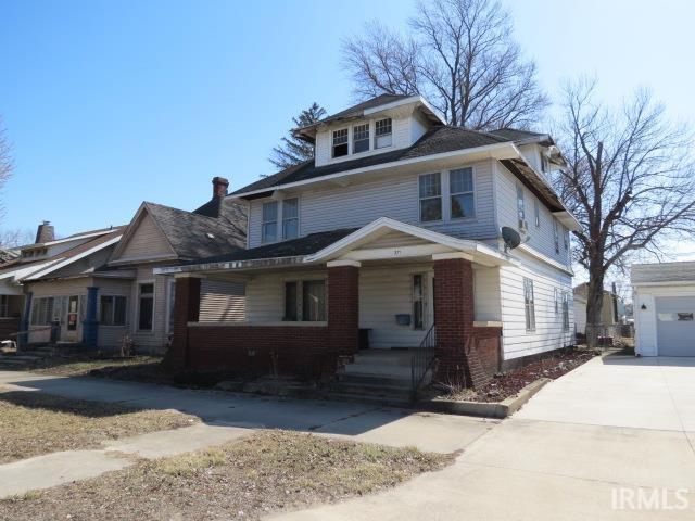 american foursquare style home with concrete driveway and an outdoor structure