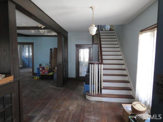 foyer with stairway, wood finished floors, and baseboards