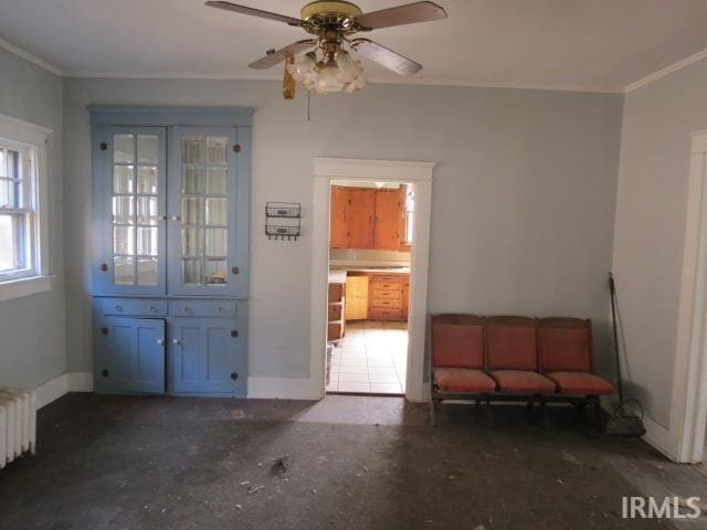 interior space featuring baseboards, radiator, and ornamental molding