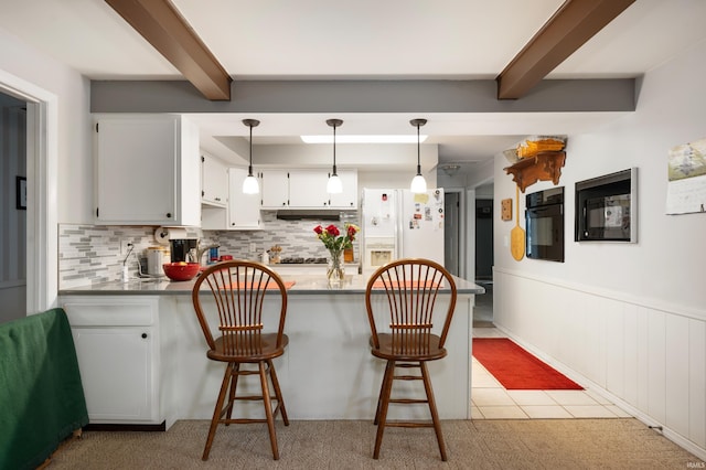 kitchen featuring backsplash, a wainscoted wall, beam ceiling, a peninsula, and white fridge with ice dispenser