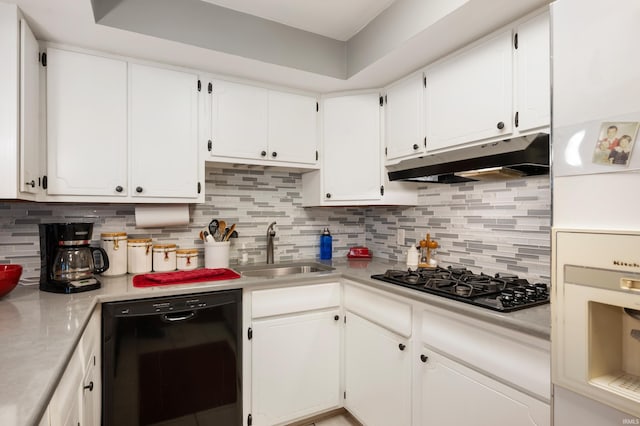 kitchen featuring black appliances, a sink, under cabinet range hood, backsplash, and light countertops