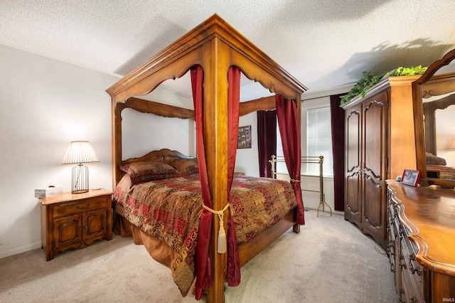 bedroom with light colored carpet, baseboards, and a textured ceiling