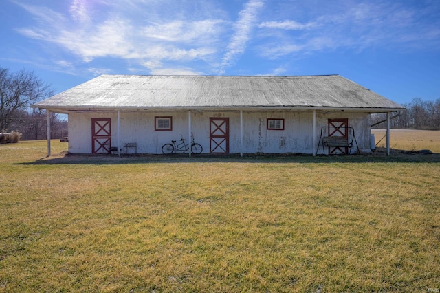 rear view of house with an outbuilding and a yard