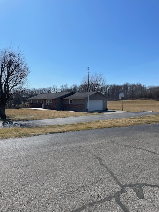 view of front of property with a front lawn, an attached garage, and driveway