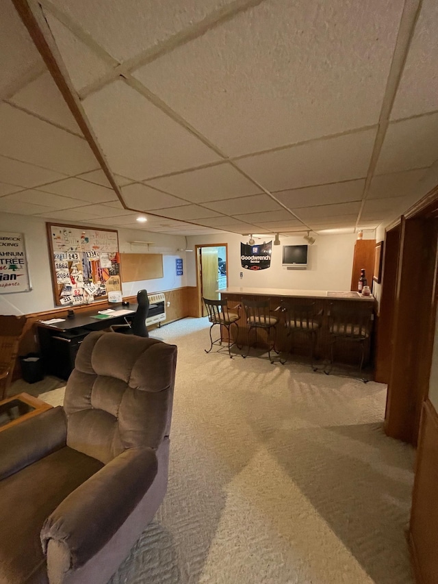 living room featuring a bar, a paneled ceiling, and carpet floors