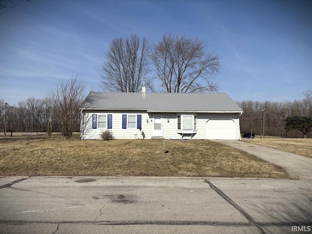 ranch-style house featuring a front yard, an attached garage, driveway, and metal roof