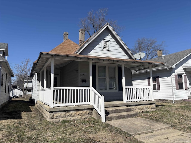 view of front facade with a porch and a chimney