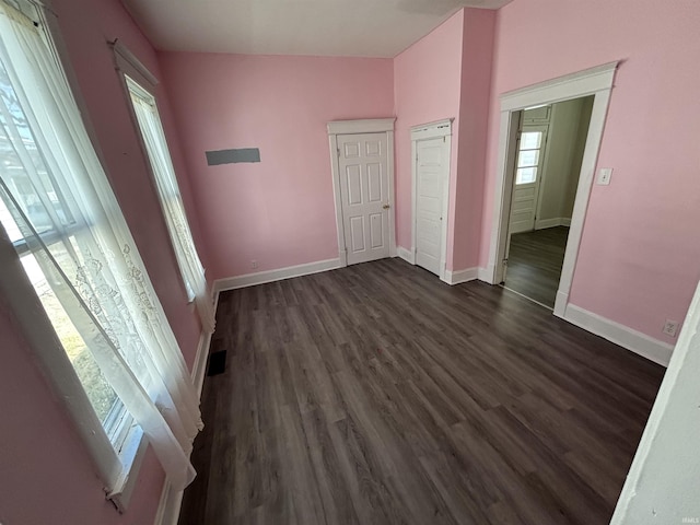 interior space featuring dark wood finished floors, visible vents, and baseboards