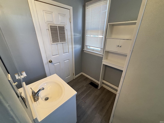 bathroom with visible vents, baseboards, wood finished floors, and vanity