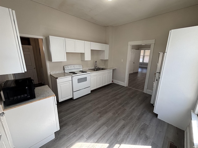 kitchen featuring a sink, light countertops, white electric range oven, and white cabinetry