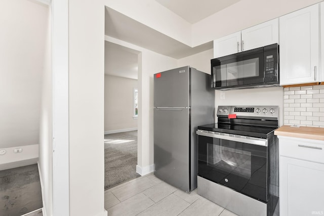 kitchen featuring tasteful backsplash, baseboards, light colored carpet, appliances with stainless steel finishes, and white cabinetry