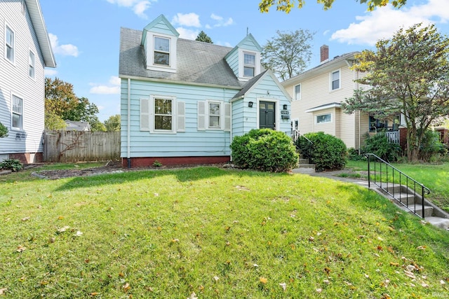 new england style home with a front yard and fence