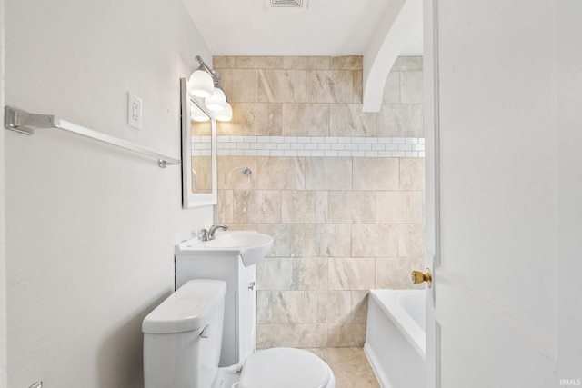 bathroom with visible vents, toilet, shower / washtub combination, tile walls, and vanity