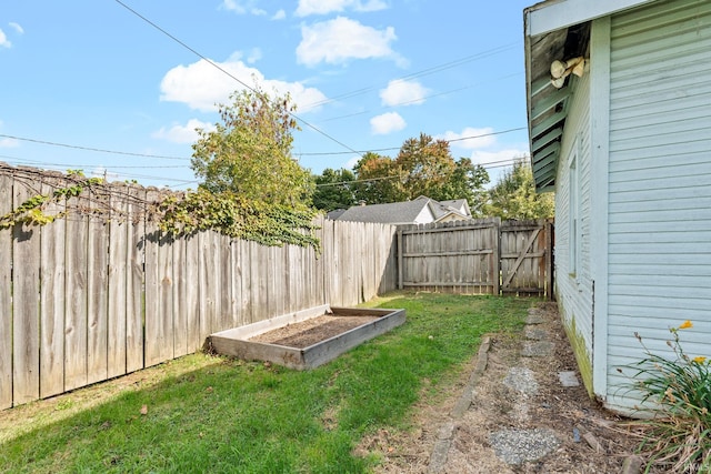 view of yard with a vegetable garden and a fenced backyard