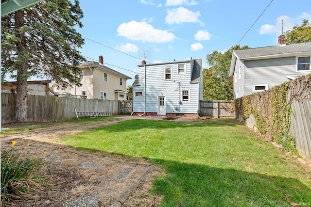 back of house featuring a yard and a fenced backyard