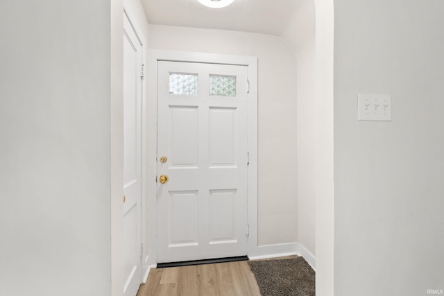 doorway featuring light wood-style flooring and baseboards