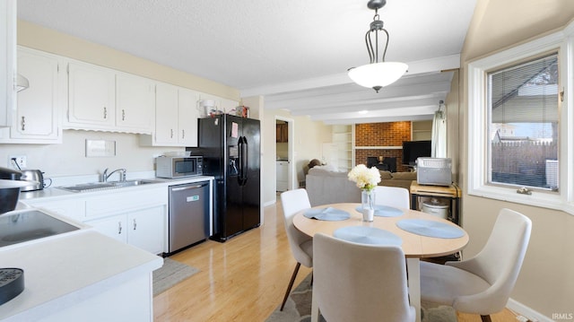 kitchen featuring a sink, light countertops, light wood-style flooring, and stainless steel appliances