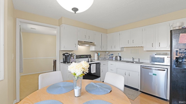 kitchen with under cabinet range hood, range with electric stovetop, white microwave, dishwasher, and black refrigerator with ice dispenser