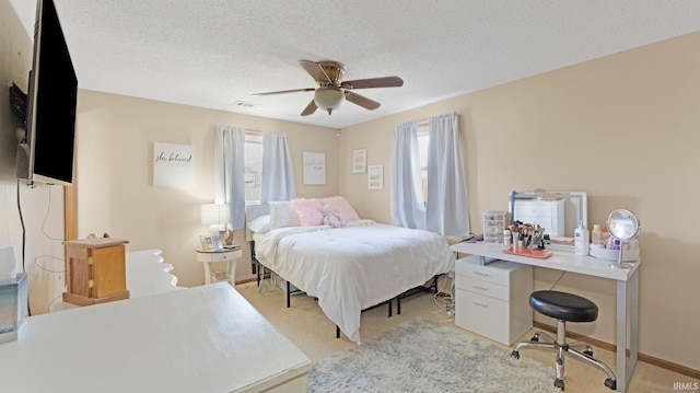 bedroom featuring visible vents, a textured ceiling, baseboards, light colored carpet, and ceiling fan