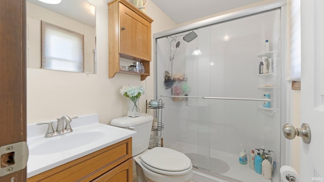 full bath with a stall shower, toilet, and vanity