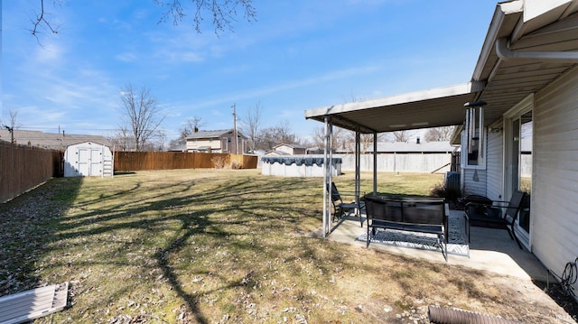 view of yard featuring an outbuilding, a patio, a fenced in pool, a fenced backyard, and a storage shed