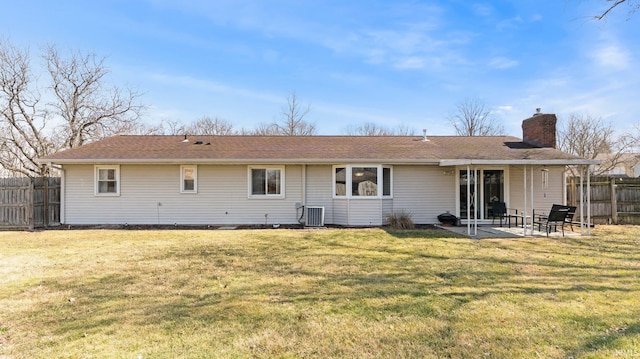 back of property featuring a patio, fence, a yard, a chimney, and central air condition unit