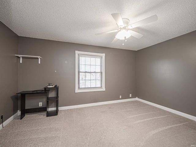 carpeted empty room featuring ceiling fan, a textured ceiling, and baseboards