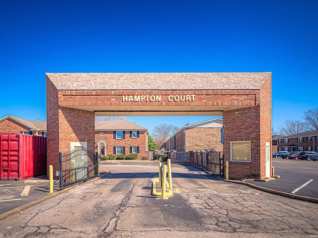 view of road featuring curbs, a gated entry, and a gate