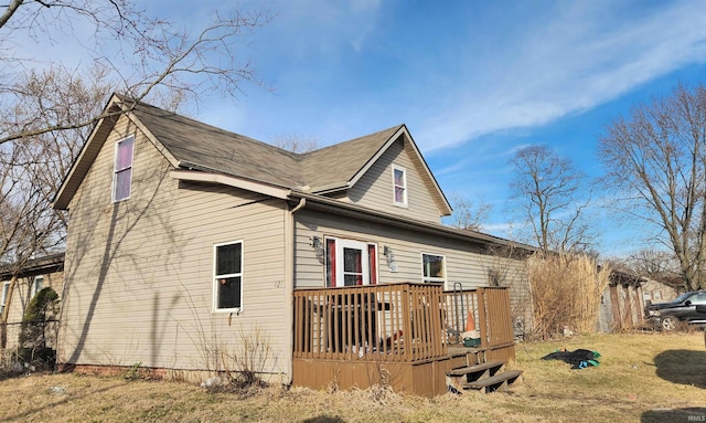 view of side of property featuring a lawn and a deck