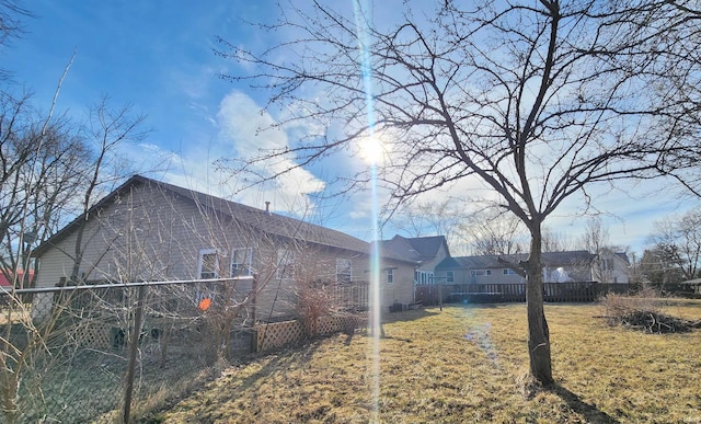 view of side of home featuring a yard and fence