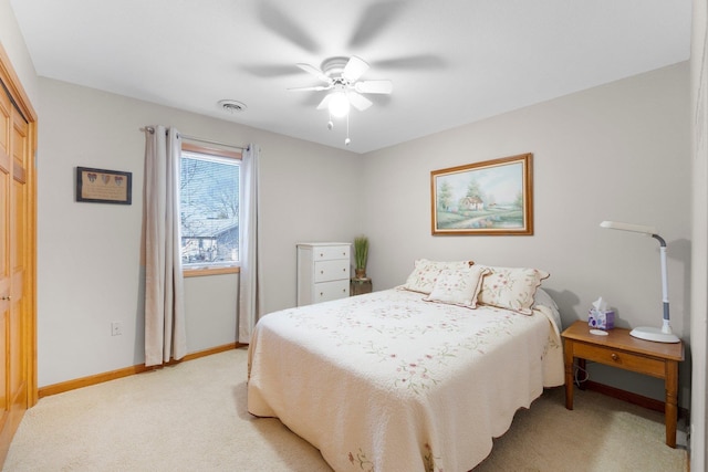 bedroom featuring visible vents, a closet, baseboards, light colored carpet, and ceiling fan