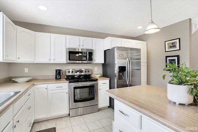 kitchen with appliances with stainless steel finishes, white cabinetry, and light countertops