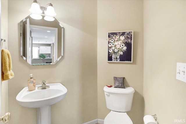 bathroom featuring a chandelier and toilet