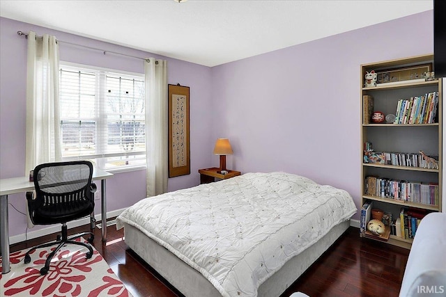 bedroom with baseboards and wood finished floors