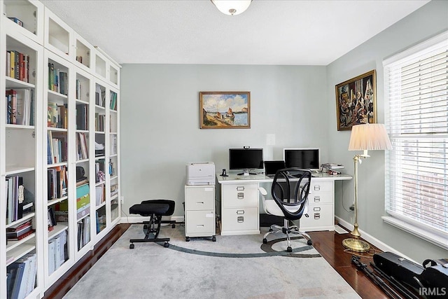 office space with dark wood-type flooring and baseboards