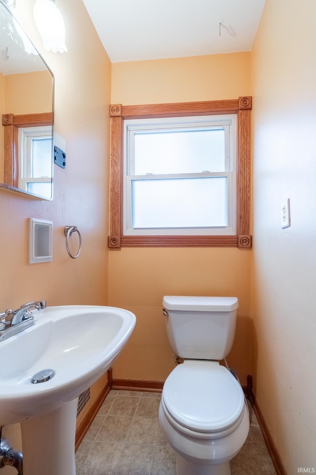 bathroom featuring baseboards, toilet, and tile patterned flooring