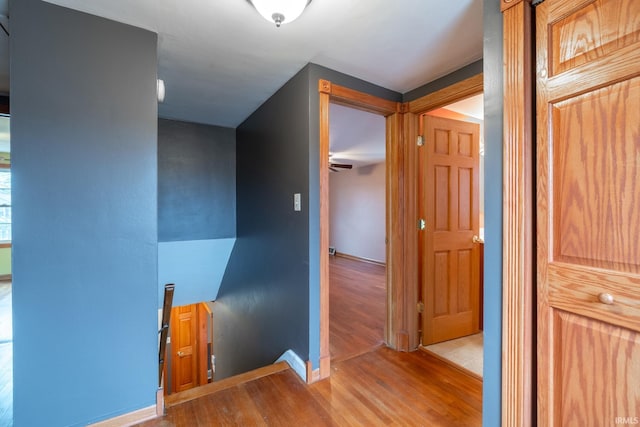 hall featuring an upstairs landing and wood finished floors