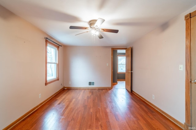 unfurnished room featuring visible vents, plenty of natural light, baseboards, and light wood finished floors