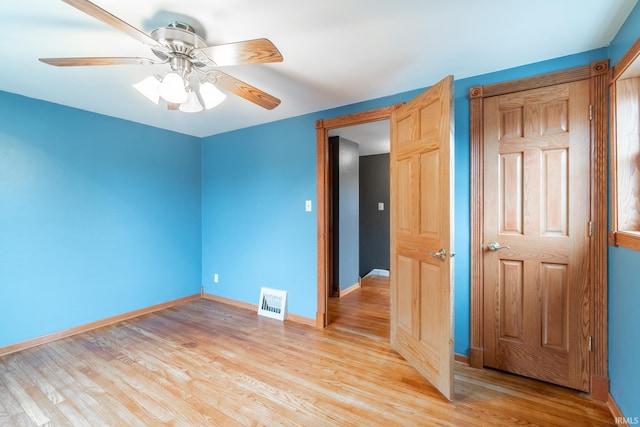 unfurnished room with baseboards, visible vents, light wood finished floors, and ceiling fan