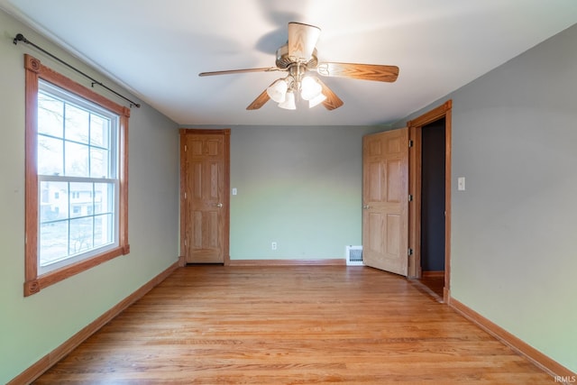 unfurnished room featuring visible vents, baseboards, light wood-style flooring, and a ceiling fan