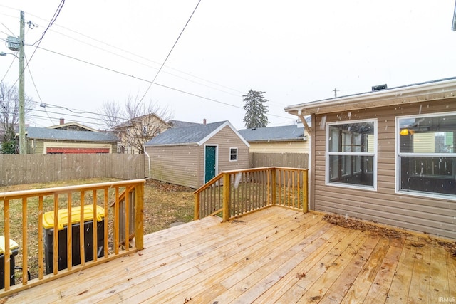 wooden terrace featuring an outbuilding and a fenced backyard