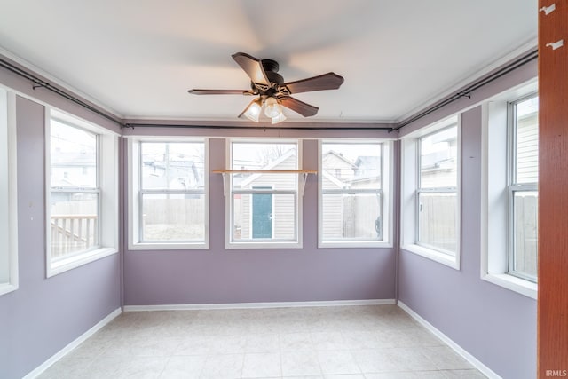 unfurnished sunroom featuring a ceiling fan