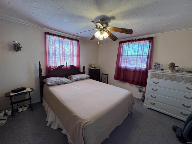 bedroom with multiple windows, a ceiling fan, and carpet floors