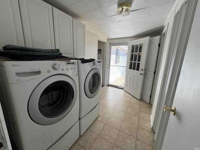 washroom featuring cabinet space, light floors, and independent washer and dryer