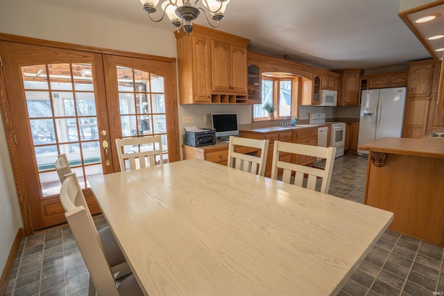 dining space featuring a chandelier, recessed lighting, french doors, and stone finish floor