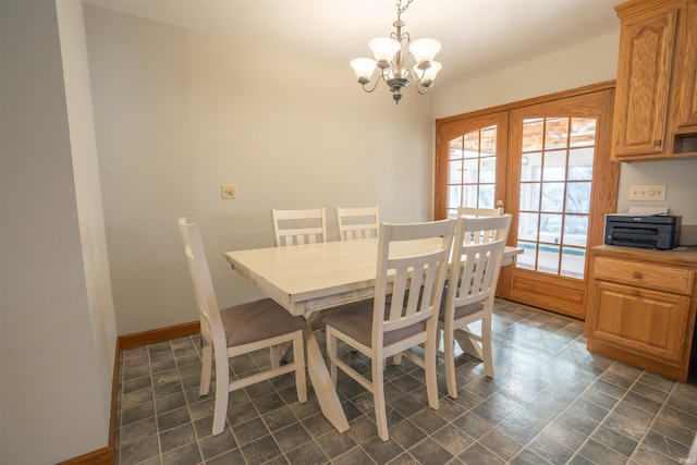 dining area featuring an inviting chandelier, french doors, and baseboards