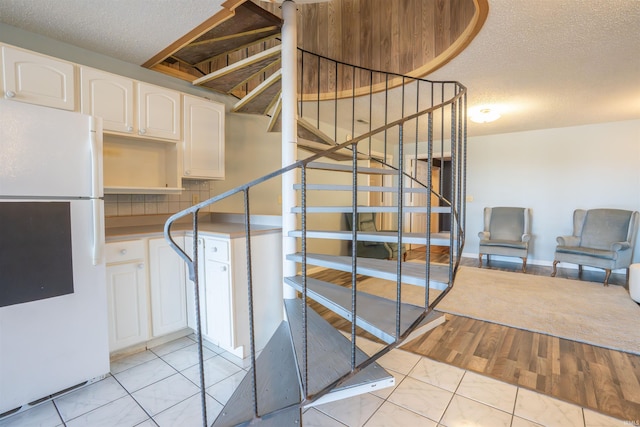 staircase featuring tile patterned floors and a textured ceiling