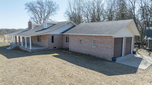 view of side of home featuring a garage, brick siding, a chimney, and a shingled roof