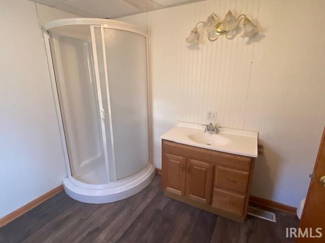 bathroom with visible vents, wood finished floors, and a shower stall