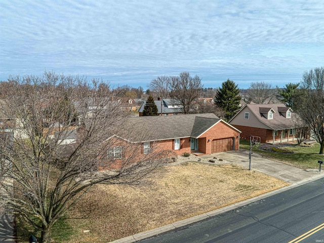 view of front of property with a front yard, brick siding, a garage, and driveway